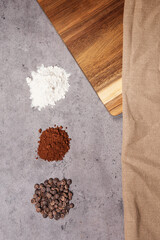 cocoa flour powder and chocolate chips and wooden table on dark marble background