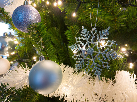 Close-up of Christmas tree decorated with blue and white ornaments and christmas lights. Image taken indoors in Olen, Belgium, December.