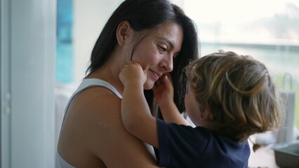Mother and small boy child love and affection. Candid mom embracing kid in arms. Authentic real...