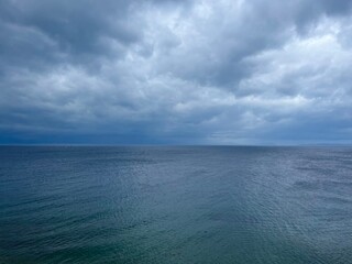 Cloudy sea view, dark clouds at the sea, rocky coast