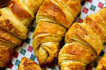 Basket of croissant bread on checkered tablecloth