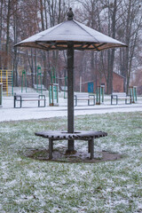 bench with a roof under the snow in a city park