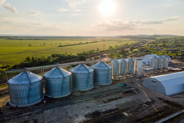 Obraz premium Aerial view of industrial ventilated silos for long term storage of grain and oilseed. Metal elevator for wheat drying in agricultural zone