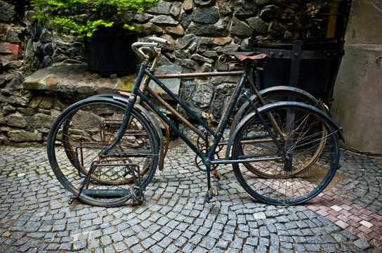 Two Old Bicycles Parked On A Stand