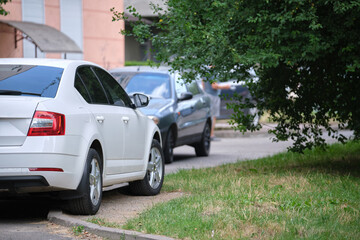 Cars parked in line on city street side. Urban traffic concept