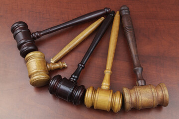 Many wooden judge gavels on table, one judge gavel broken. Symbol corruption and bribes in legal system.