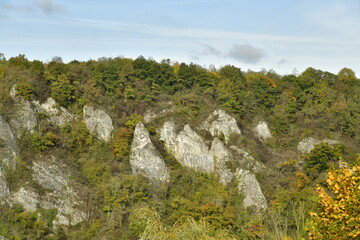 Fototapeta premium Pans de rochers parmi la végétation luxuriante des collines en automne à anseremme au sud de Dinant 