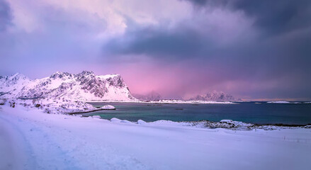 Amazing winter nature scenery. Colorful sky over the sea, snowy mountains and north fjord  snow covered mountains. Norway. Lofoten islands during sunset, Stunning Norway landscape. 