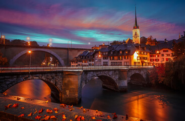 Wonderful vivid cityscape. Scenic view Historical Old Town of Bern city, bridges over Aare river and church tower during dramatic sunset. Bern. Switzerland. Europe