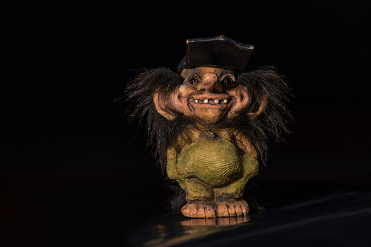 Clay doll of a smiling troll boy.
