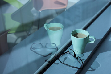 A cup of coffee on the ledge of office window