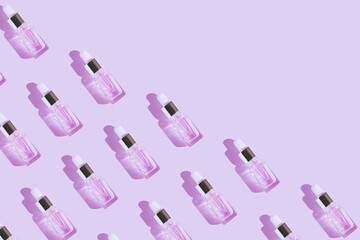 Creative pattern made of transparent bottle with pipette of hyaluronic acid serum with collagen or essential oil on pastel background with shadow. Natural treatment concept. Flat lay