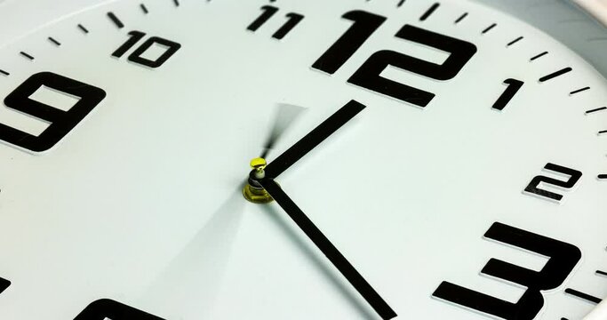 Close-up time lapse of a  modern gray wall clock with numerals on the clock face. Selective focus on the number 5 or 5 o'clock. The seconds pointer overtake the minutes frequently. Time passing fast