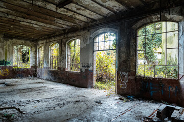 inside of a abandoned factory with view outside to the green forest