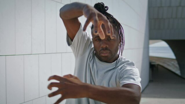 Flexible guy dancing hands closeup. Dreadlocks dancer man training freestyle