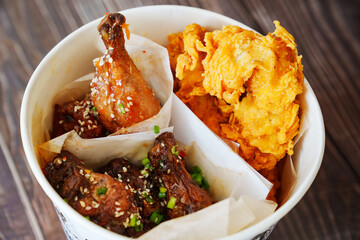 caramelized chicken with sesame and garlic, meat strips in paper bucket 