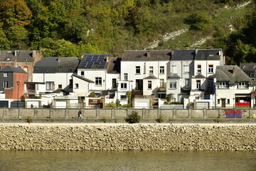 Fototapeta na wymiar Façades arrières de maisons ouvrières traditionnelles longeant la Meuse au niveau très bas à Dinant 