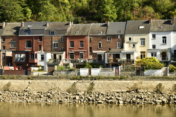 Façades arrières de maisons ouvrières traditionnelles longeant la Meuse au niveau très bas à Dinant 