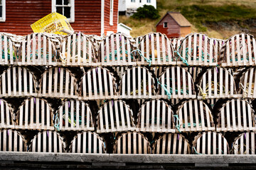 Wooden lobster traps stacked on a boat dock near the small fishing village of Trinity Newfoundland Canada.