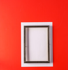 Wooden frame on red bright background, the concept of minimalism