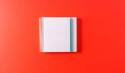 An empty A4 notebook on red paper background, top view,mockup.