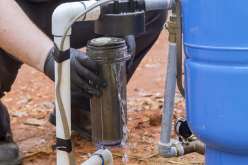 Worker performs maintenance on equipment, including replacement of water filters that will be used