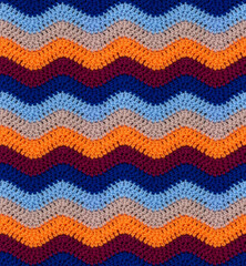Seamless knitted pattern in the form of zigzags crocheted with threads of contrasting colors....