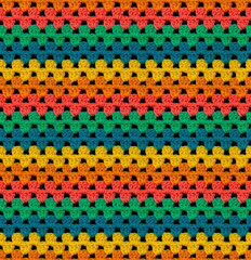 Bright seamless knitted texture. The pattern is crocheted from multi-colored acrylic yarn. Zigzag shapes. African motives. 