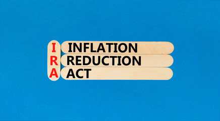 IRA inflation reduction act symbol. Concept words IRA inflation reduction act on wooden sticks on beautiful blue table blue background. Business IRA inflation reduction act concept. Copy space.