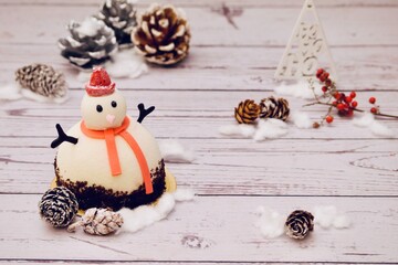 Snowman cake and christmas decoration on the table. Christmas background.