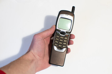 Old mobile phone slider in man's hands. Pastime, Retro technology.