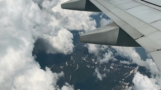 Flying over islands of beautiful clouds over a mountain landscape -Aerial