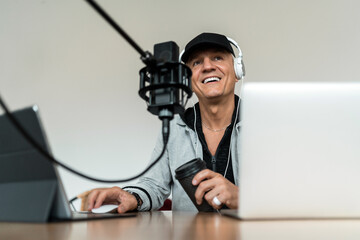 The host streams, online communication broadcast. An adult male workplace in the studio at home, uses equipment laptop, microphone.
