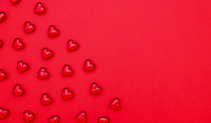 Red glass and small hearts lie on the left on a red background.