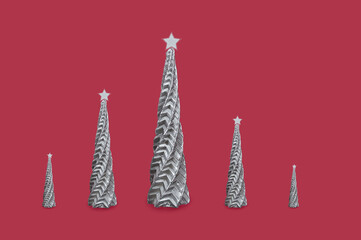 A set of silvery wax candles in shape of a Christmas tree on a red background.