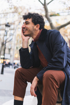 Cheerful male sitting on street