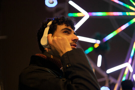 Man in headphones on street in evening