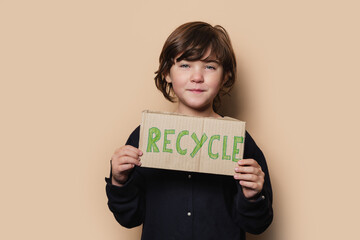 Girl showing Recycle placard at camera