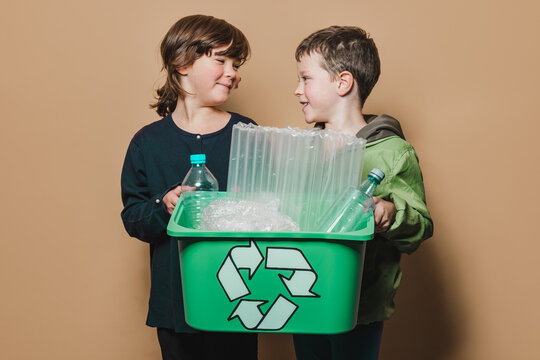 Siblings with box of recyclable trash