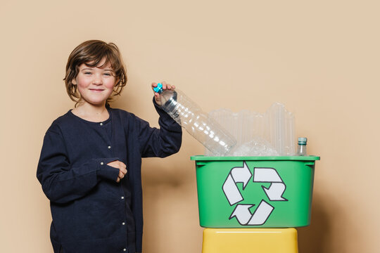 Cheerful girl smiling and sorting garbage