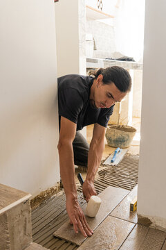 Focused worker laying clinker tile