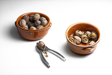 Noci in ciotole di terracotta e schiaccianoci