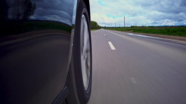 Driving a car on a country road, Wheel spinning in sunset, Low camera position 
