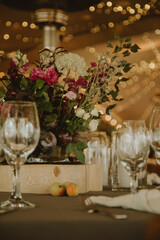 table with glasses and a bouquet of flowers. Event decoration.