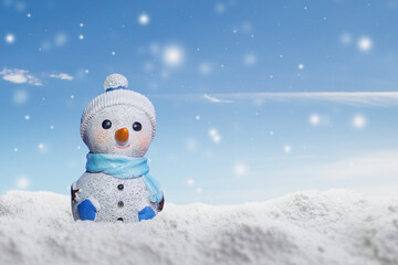 Cute snowman on snow with blurred background and sky. Winter snow. Winter postcard. Vacations, holidays. Looking straight into the cameraWinter banner.