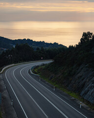 Road next to the Atlantic Ocean in Finisterre in Galicia, Spain in an autumn sunset.