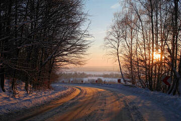Droga o zachodzie słońca zimą i ostry zakręt. - obrazy, fototapety, plakaty