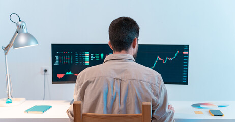 Unrecognizable man looking at computer checking stock exchange market trader graphics. Investor broker analyzing indexes