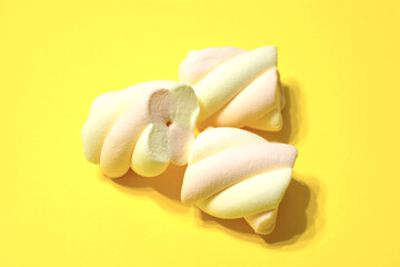 group of cream marshmallows isolated on yellow background, macro