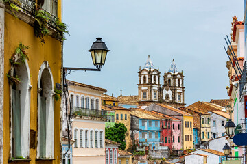 Fototapeta na wymiar Colorful historical colonial houses facades and antique church tower in baroque and colonial style in the famous Pelourinho district of Salvador, Bahia